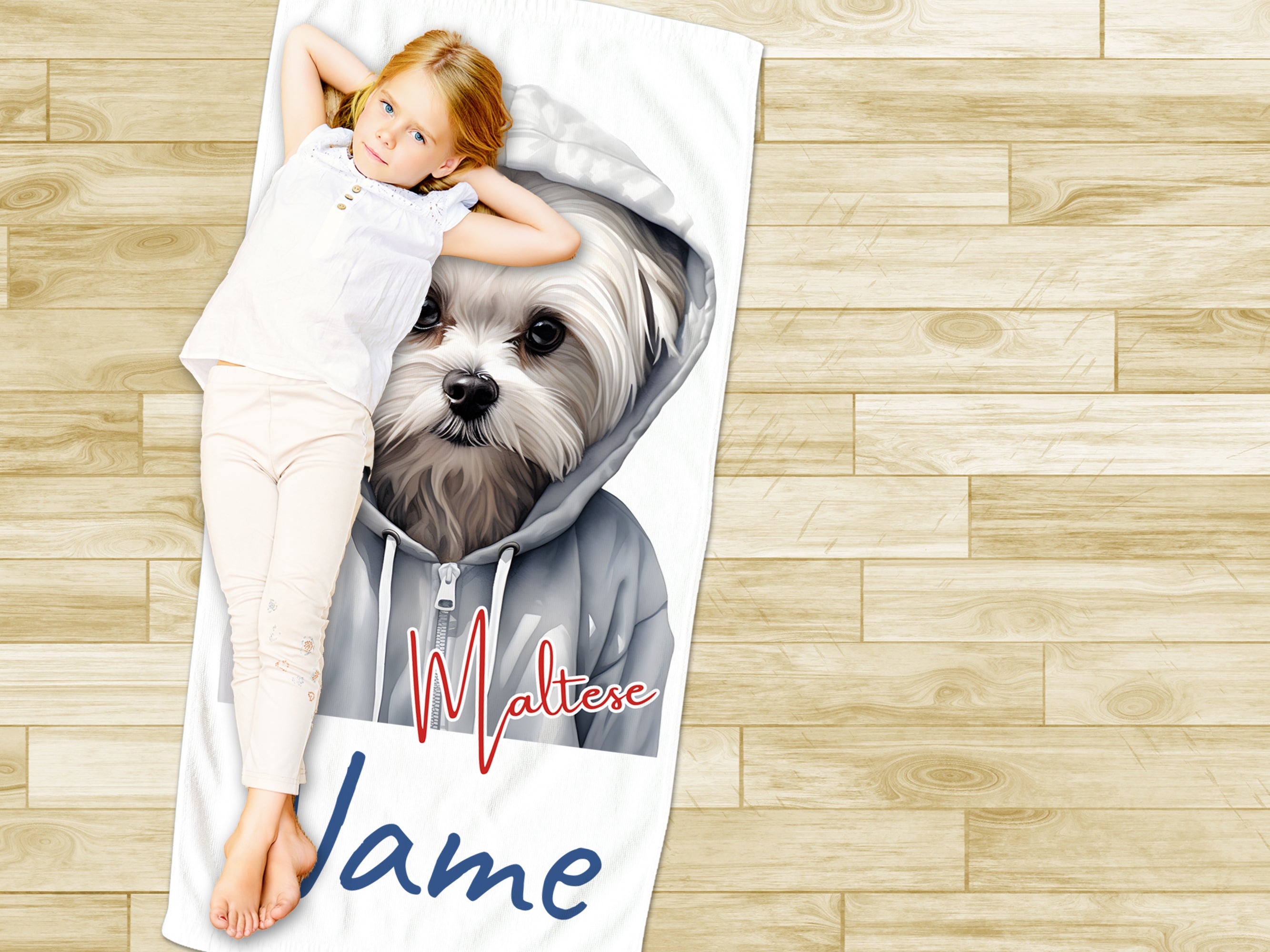 Mädchen liegt auf Handtuch mit Malteser-Hund und Namen.