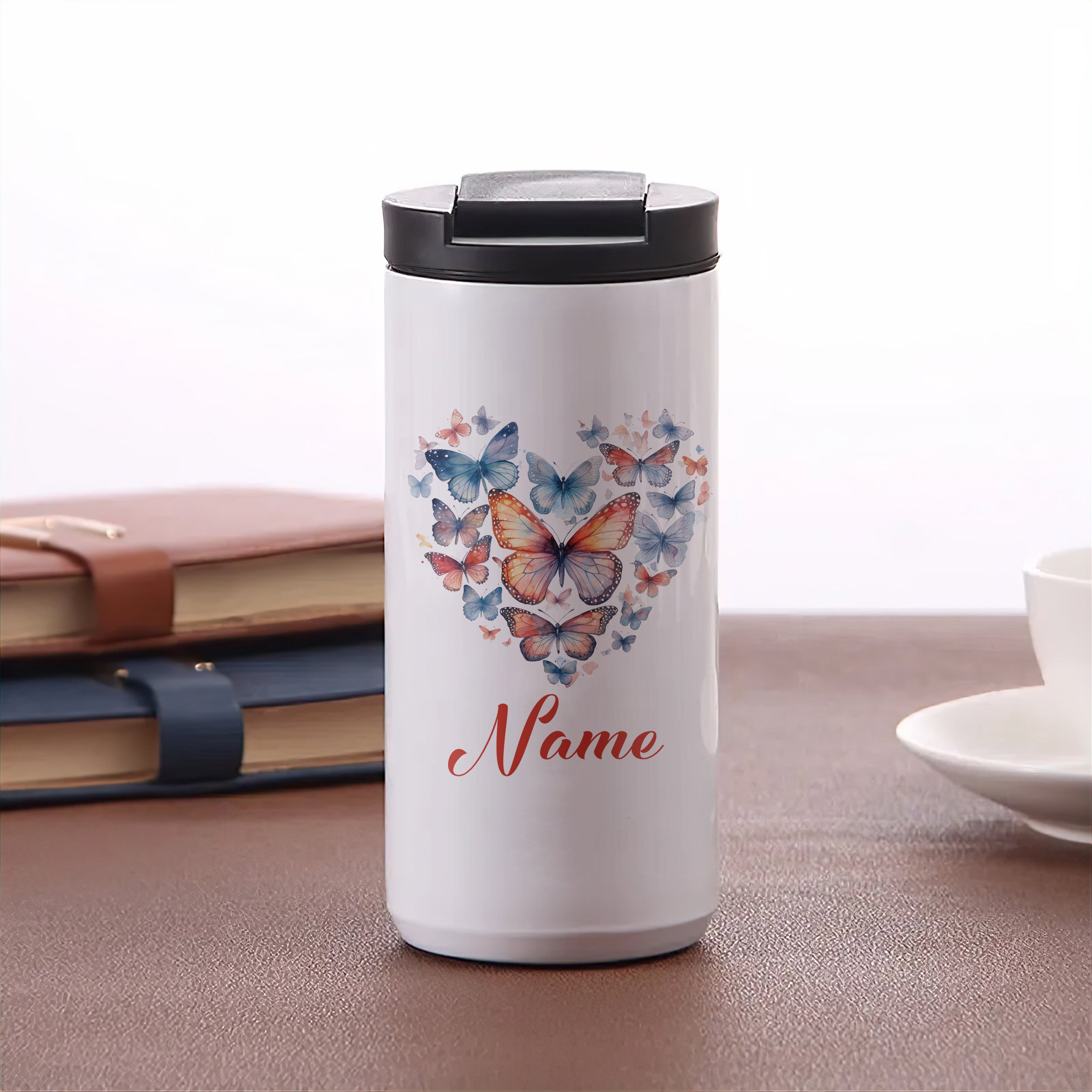Weißer Thermobecher mit bunten Schmetterlingen und personalisierbarem Namen.