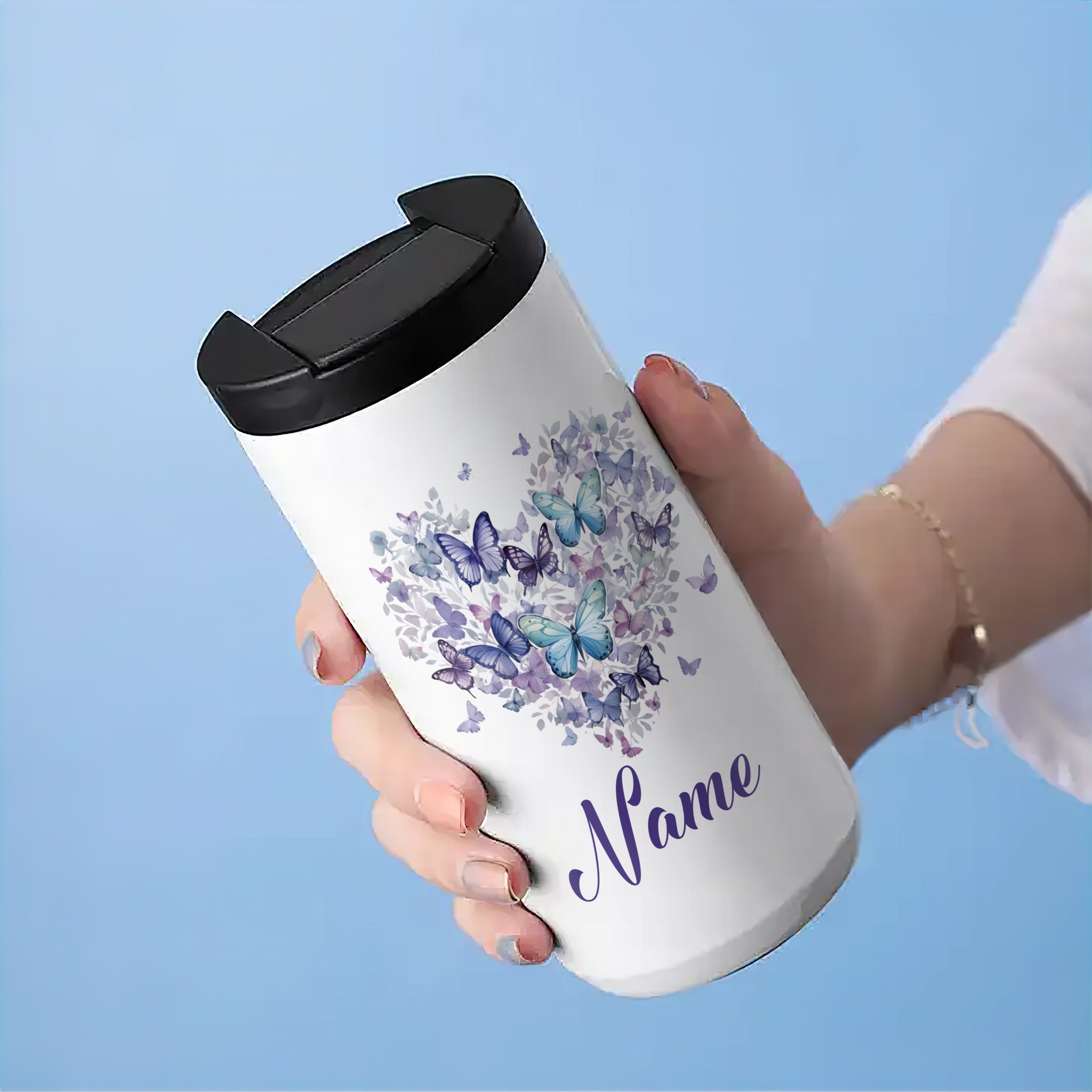 Weißer Thermobecher mit lila Schmetterlingen und personalisiertem Namen.