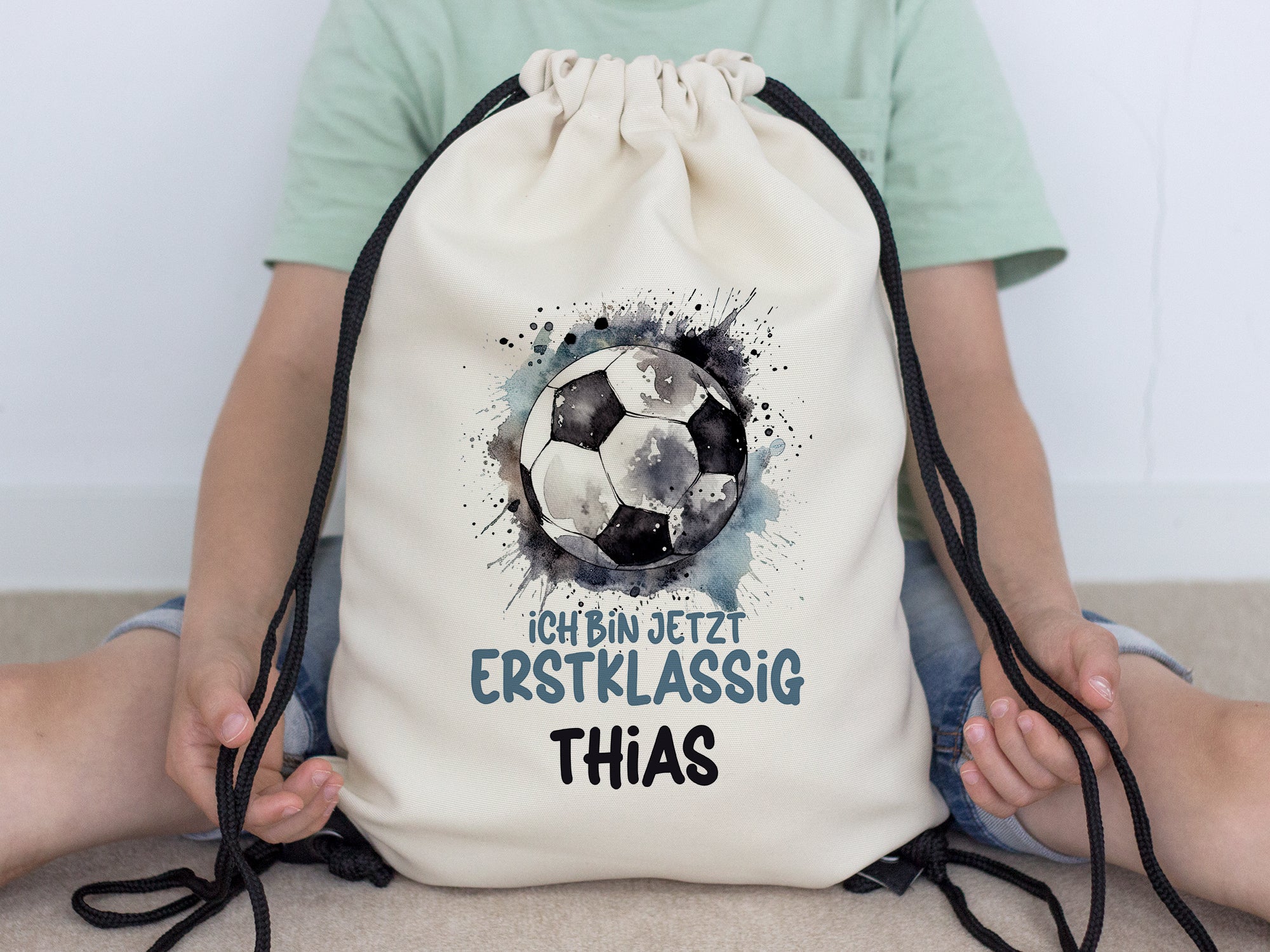 Beige Sportbeutel mit Fußball-Motiv und personalisiertem Text.