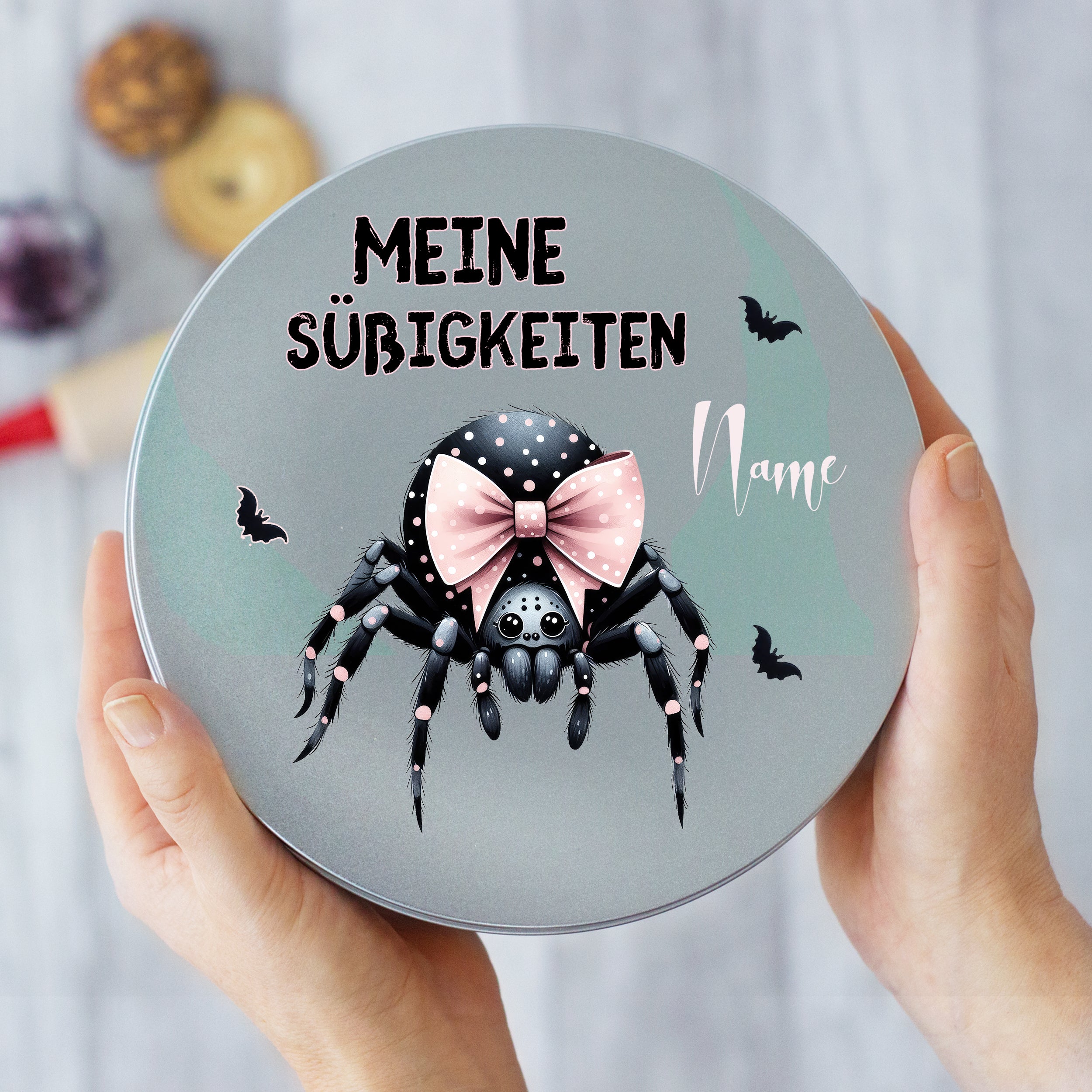 Graue Dose mit Spinne und rosa Schleife, personalisierbar.
