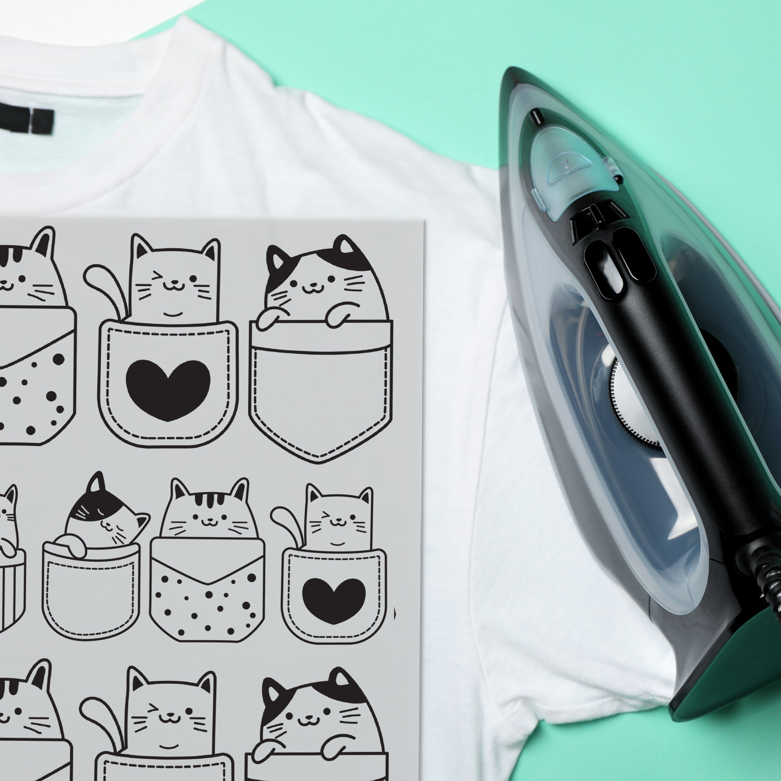 Weißes T-Shirt mit Katzenmuster und schwarzem Bügeleisen.