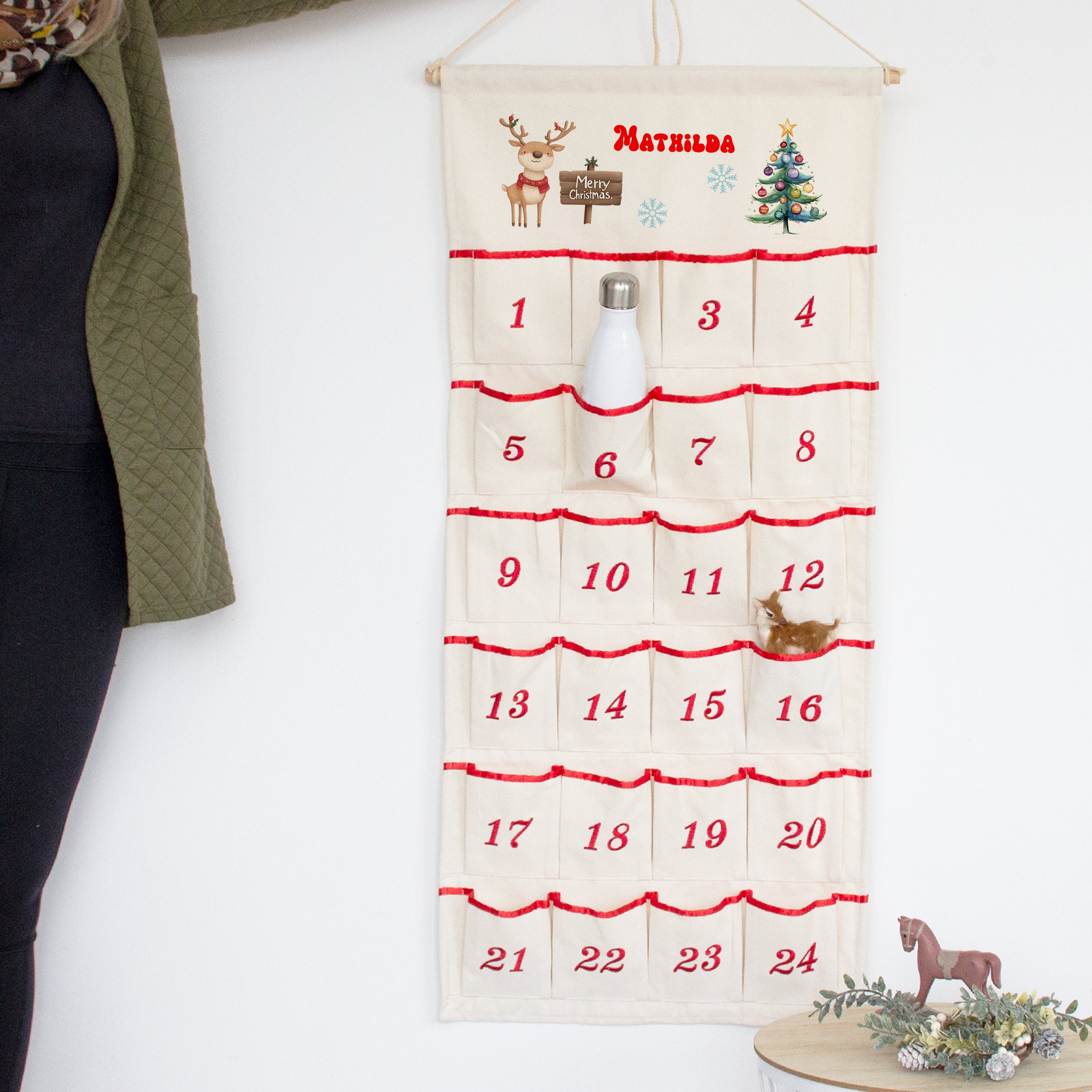 Adventskalender aus Stoff mit roten Akzenten und Weihnachtsmotiven.