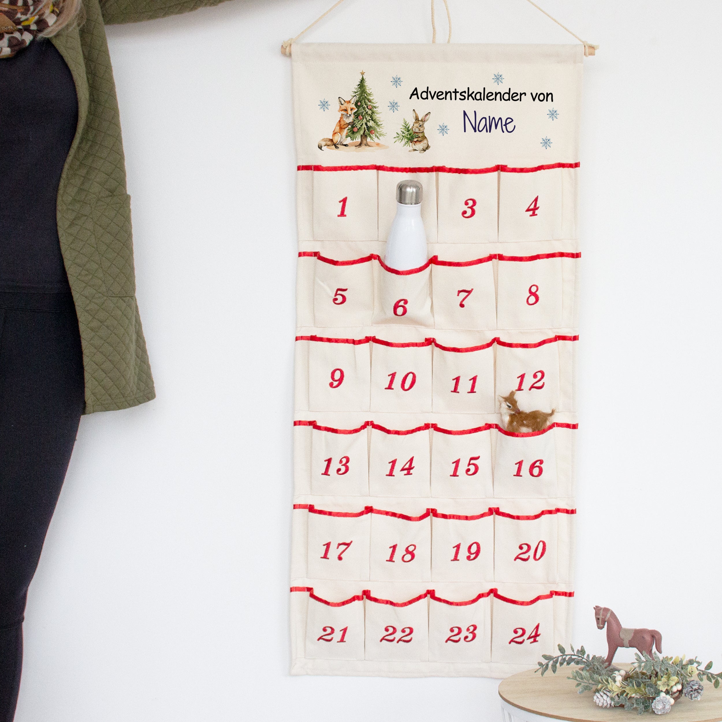 Adventskalender aus Stoff mit roten Akzenten und Weihnachtsmotiven.
