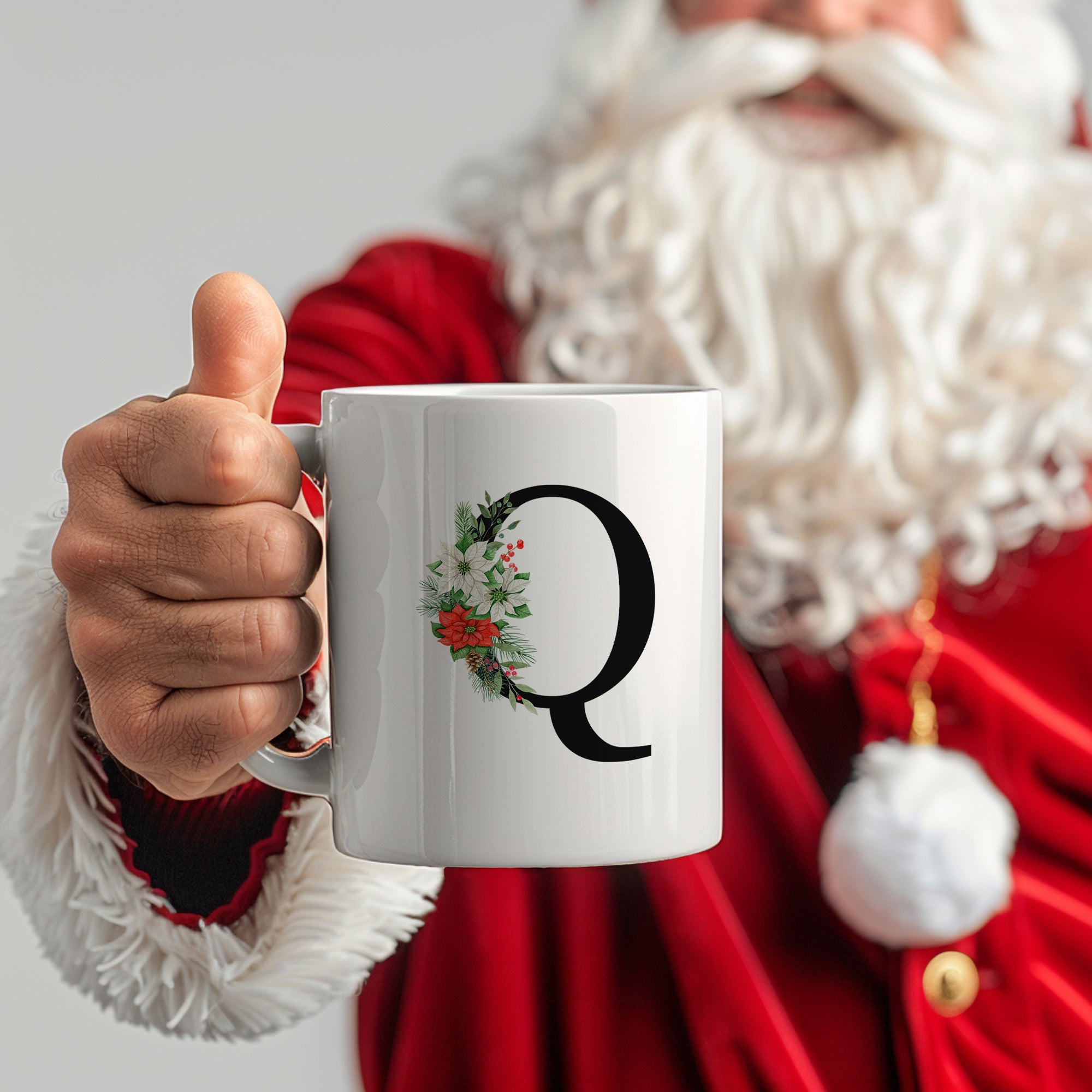 Weißer Becher mit schwarzem "Q" und Weihnachtskranz.