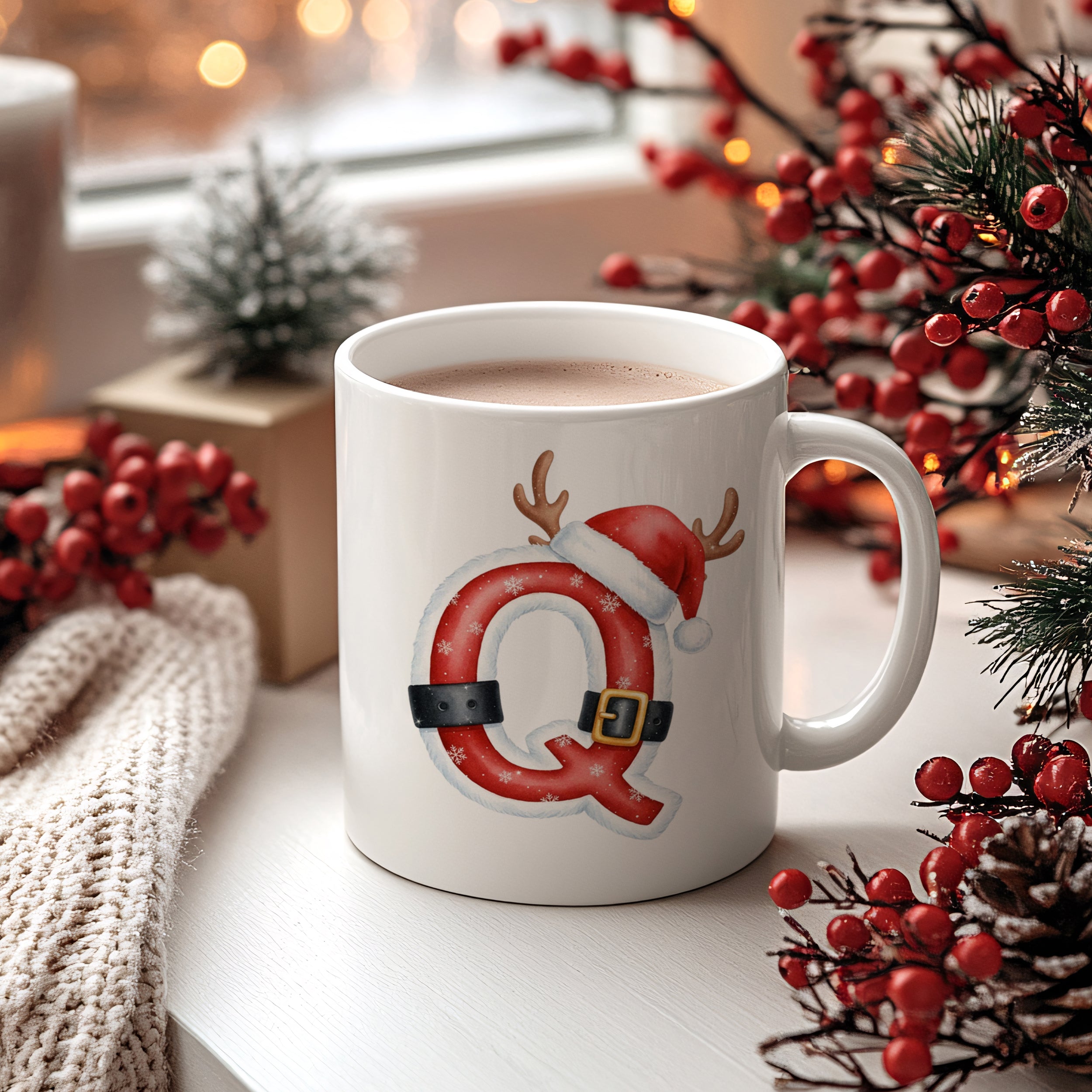 Weißer Becher mit rotem Weihnachtsbuchstaben Q und Rentiergeweih.