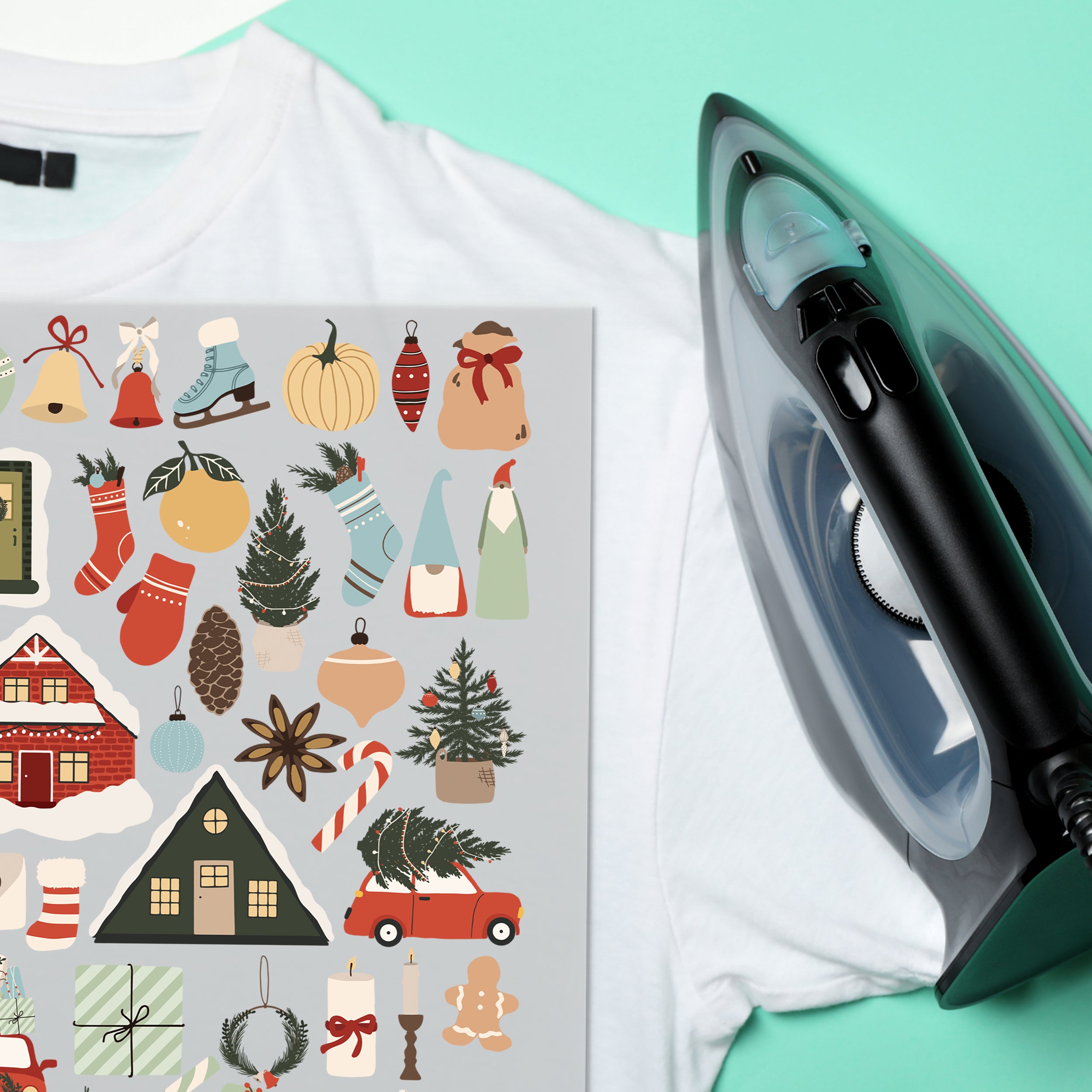 Weihnachtliche Bügelbilder auf weißem T-Shirt neben einem Bügeleisen