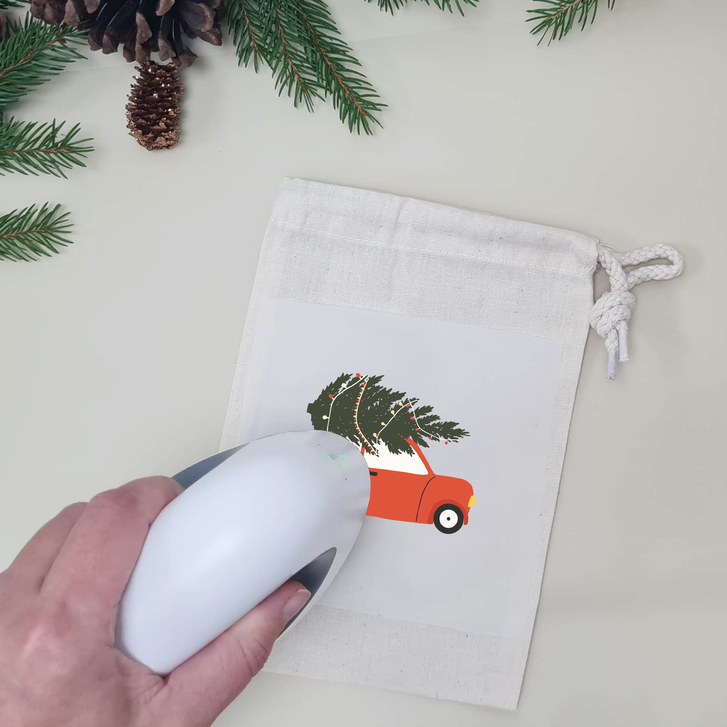 Naturfarbener Stoffbeutel mit aufgebügeltem roten Auto und Weihnachtsbaum