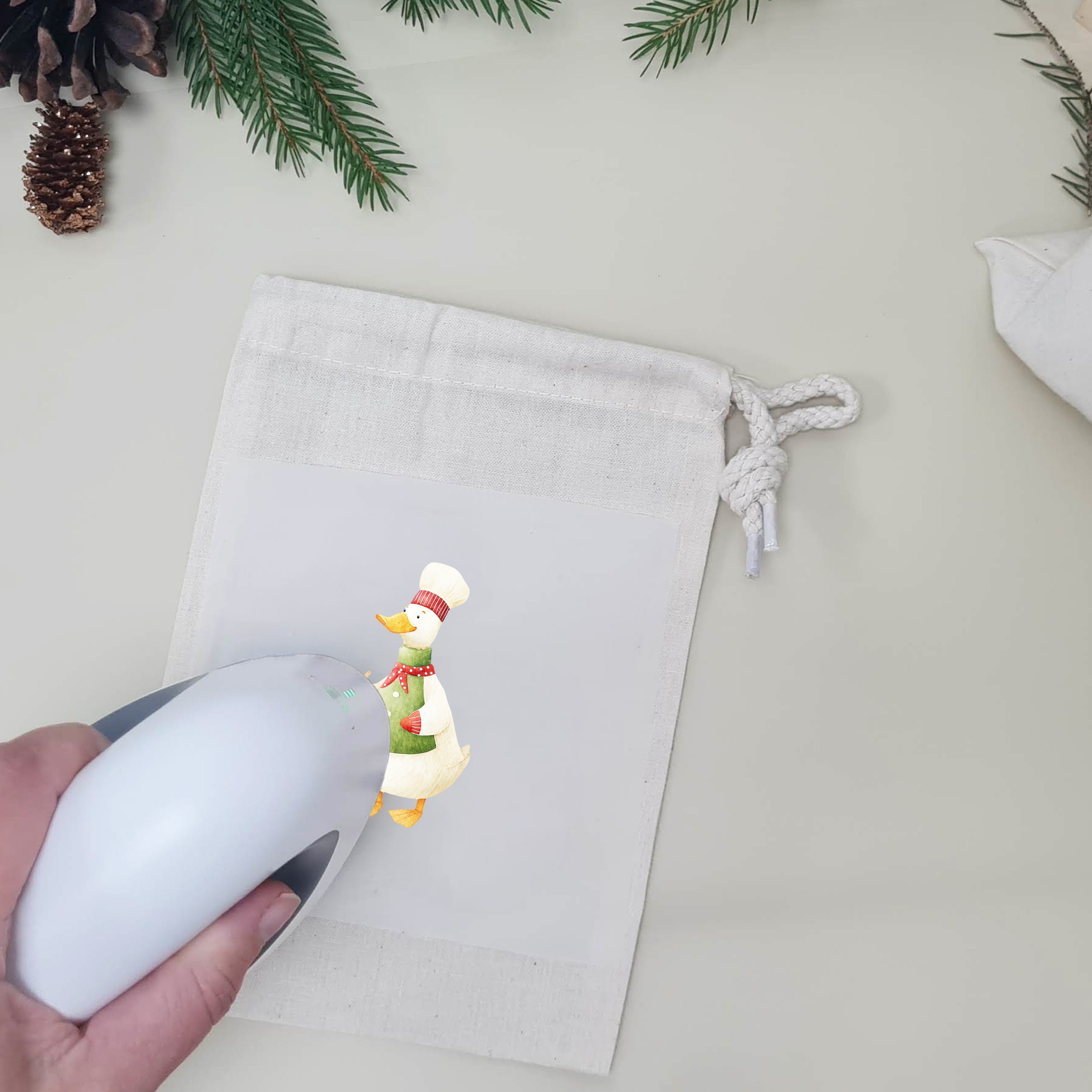 Naturfarbener Stoffbeutel beim Aufbügeln einer Weihnachtsgans mit Kochmütze