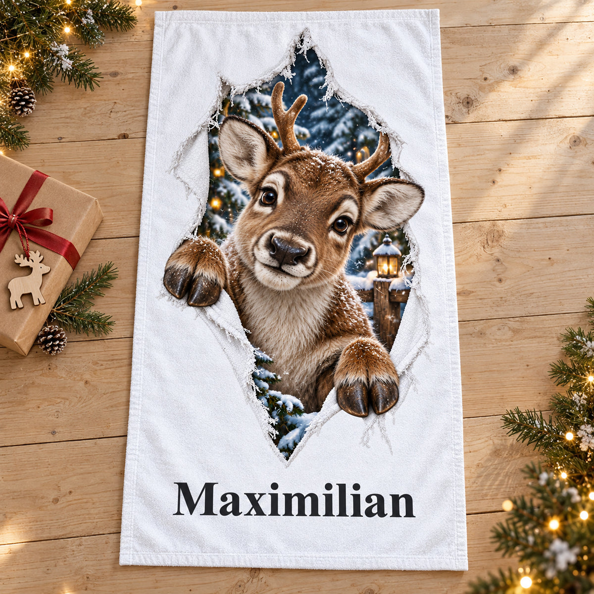 Weißes personalisiertes Handtuch mit Rentierjunges-Motiv im gedruckten Stoffriss-Design in einer weihnachtlichen Geschenkszene.
