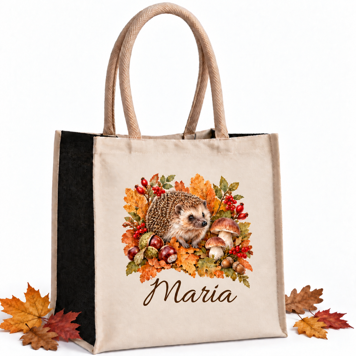 Einkaufstasche mit herbstlichem Igel-Motiv und Wunschname mit herbstlichen Blättern als Dekoration auf weißem Hintergrund.