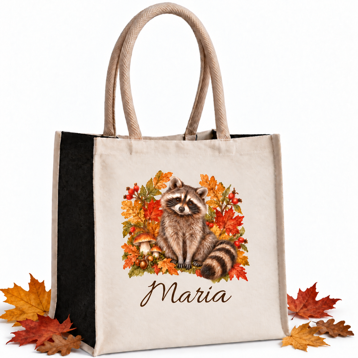 Einkaufstasche mit herbstlichem Waschbär-Motiv und Wunschname mit herbstlichen Blättern als Dekoration auf weißem Hintergrund.