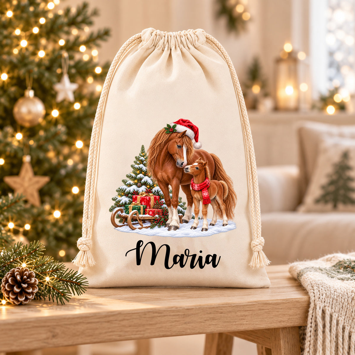 Nikolaussack mit braunem Pferd und Fohlen neben einem Geschenkschlitten und dem Namen Maria auf einer hellen Holzablage in weihnachtlicher Wohnumgebung.