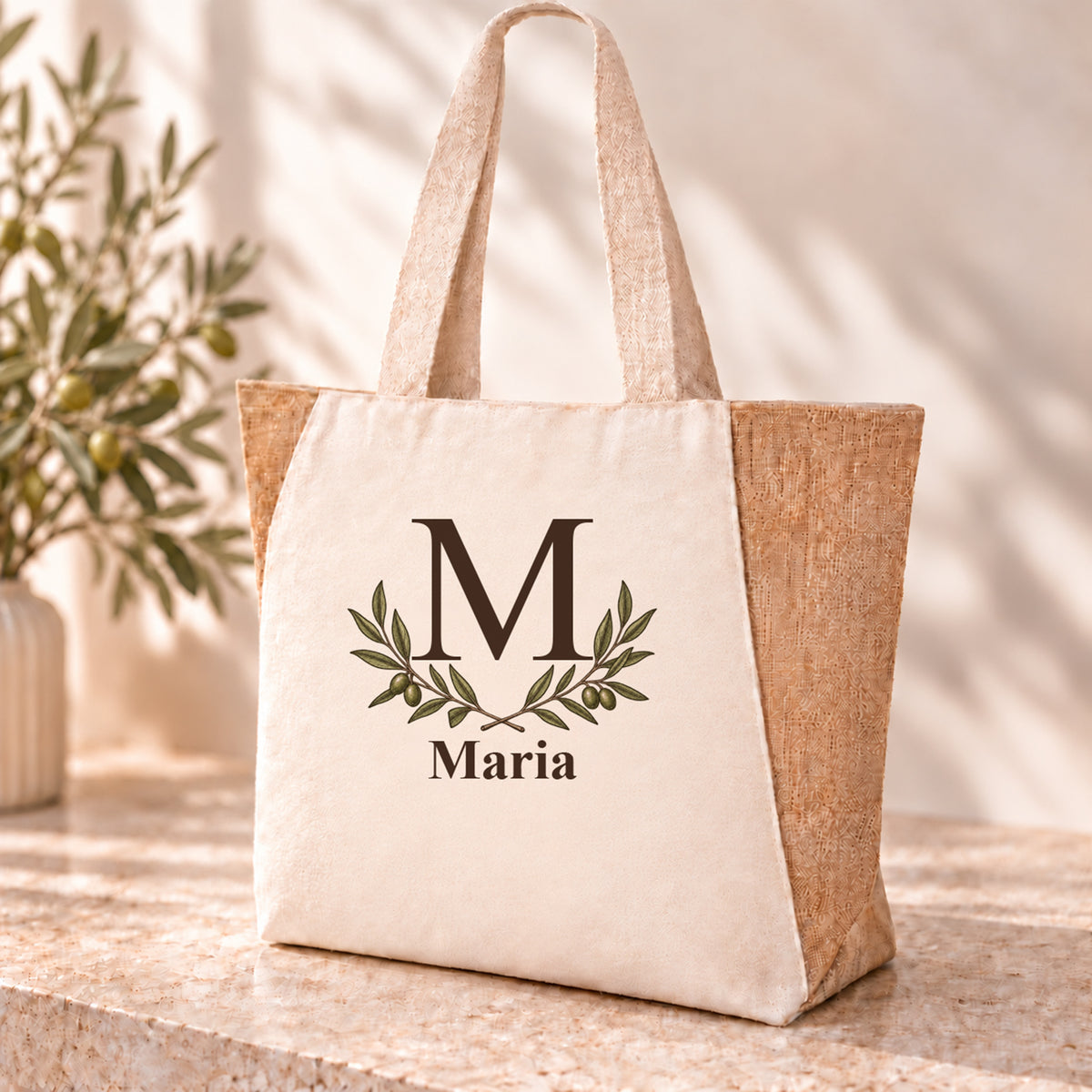 Personalisierter Shopper mit Olivenzweigpaar, Initial und Wunschname auf naturfarbener Front.